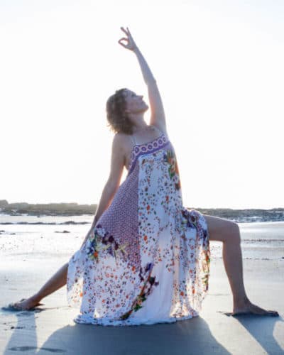 Dagmar doing warrior II pose on the beach